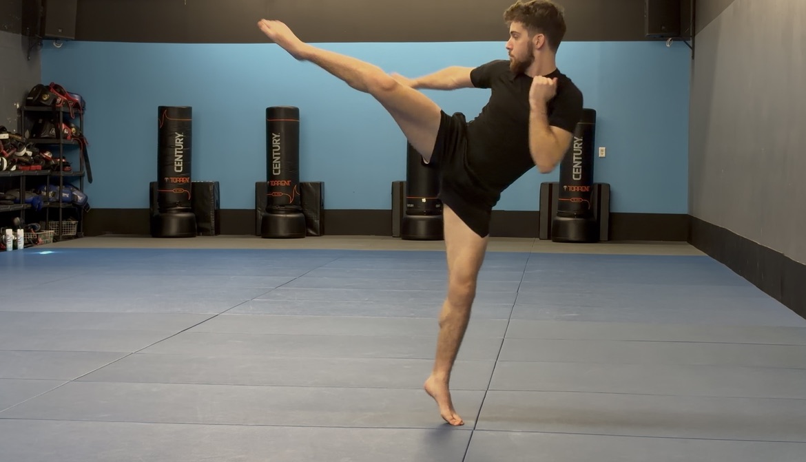 Charlie Wilson throwing a high kick on the training mats